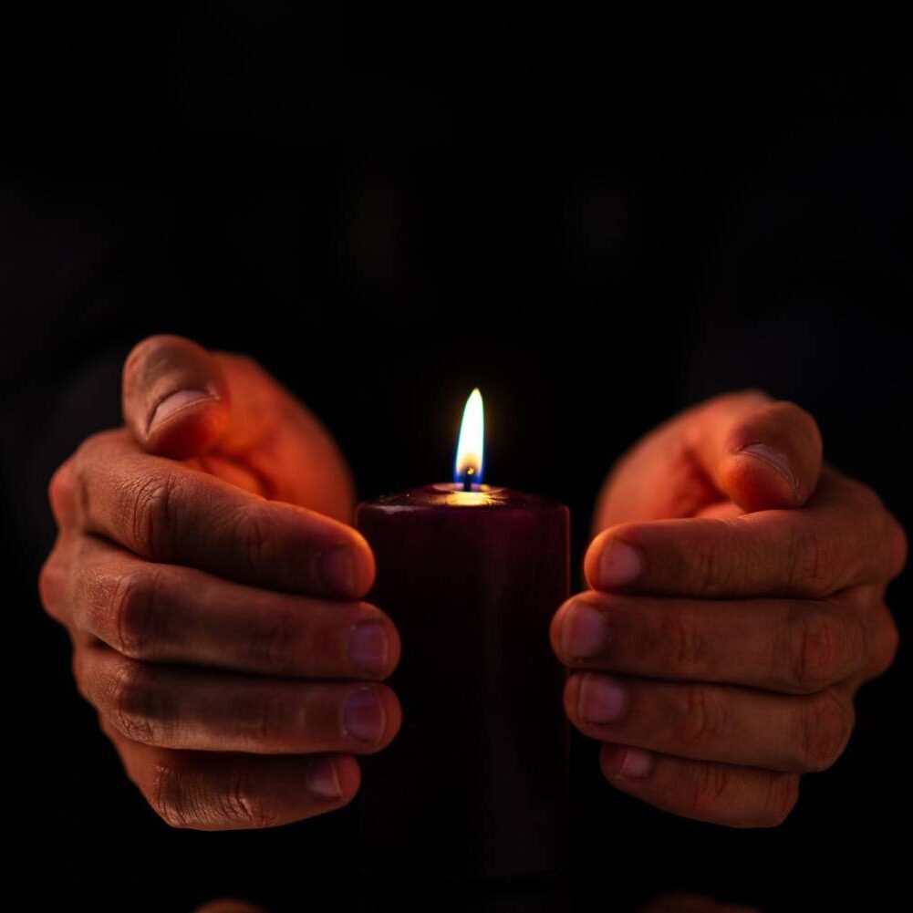Front view of dark candle with male on a dark surface